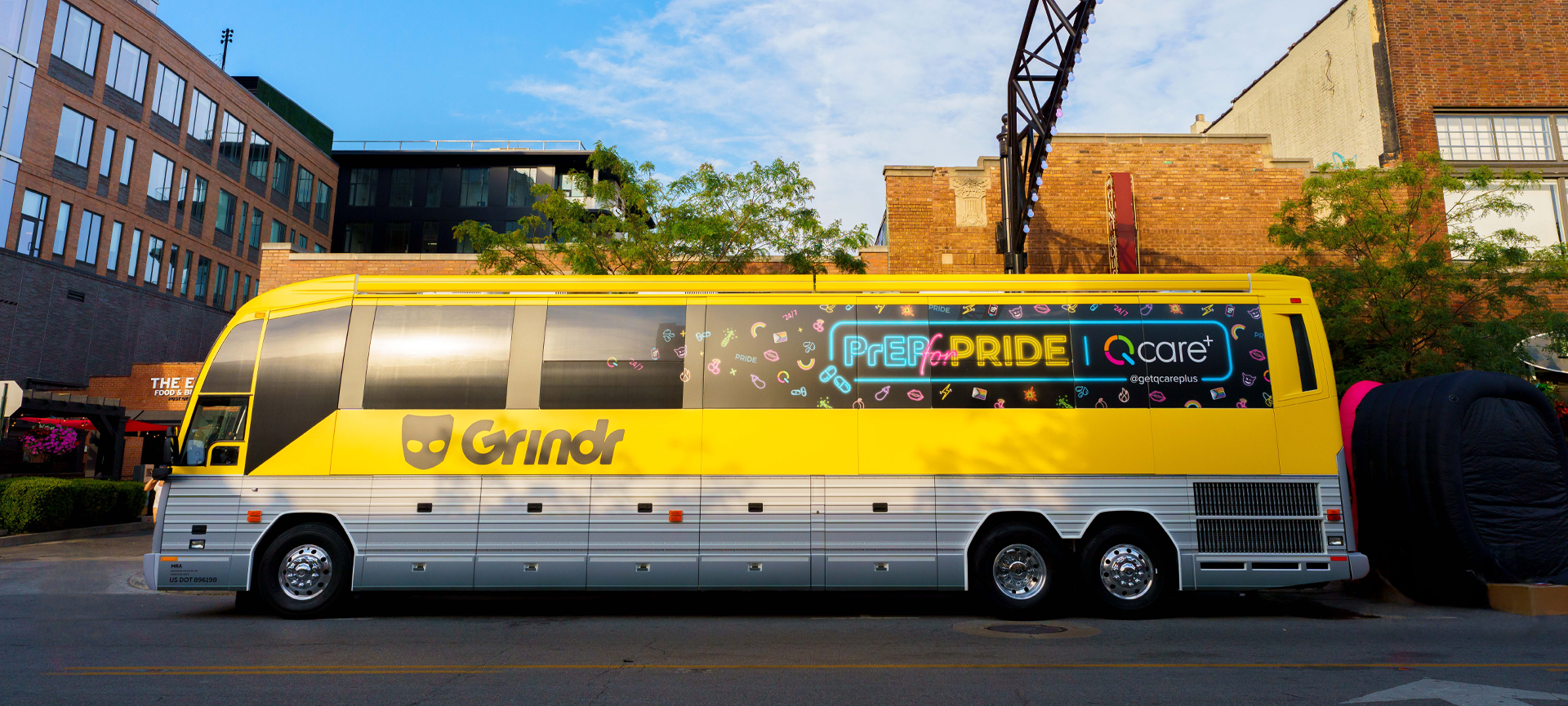 Grindr-branded tour bus featuring a "PrEP for PRIDE" advertisement by Q Care Plus, promoting HIV prevention during Pride events.