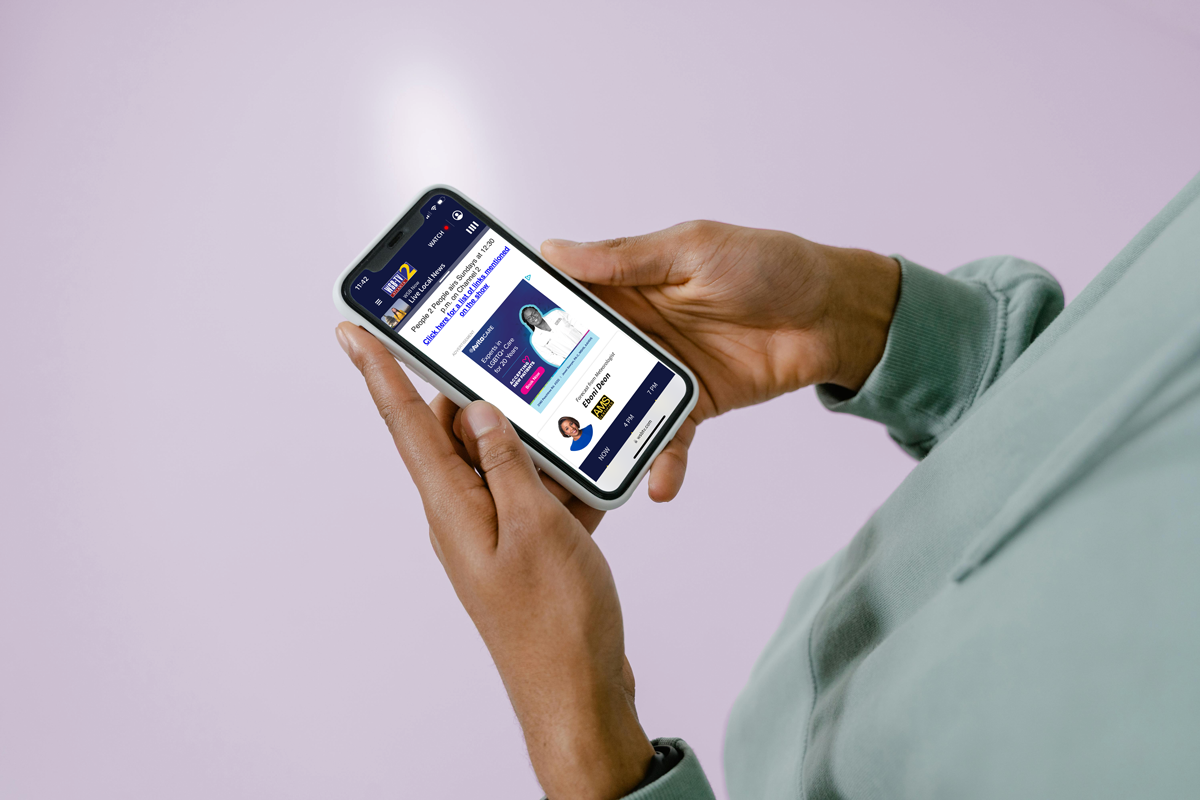 Person holding a smartphone displaying a programmatic ad for AvitaCare Atlanta with a focus on accessible healthcare services and featuring a care provider by a top ad agency.